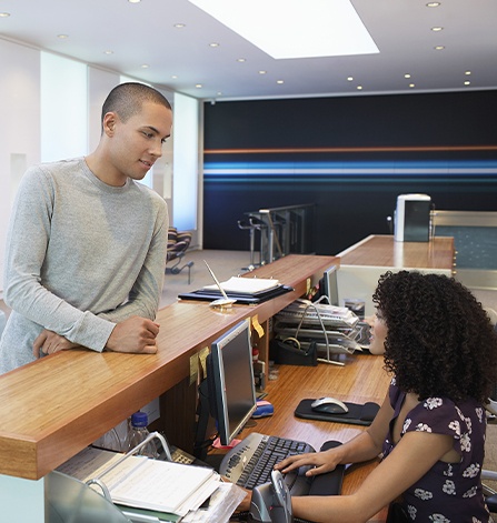 Man checking in at dental office reception desk