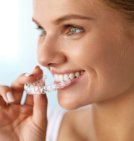 Woman placing Invisalign tray