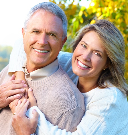 Older man and woman smiling outdoors