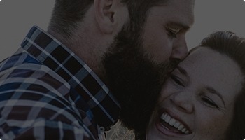 Man kissing laughing woman on cheek