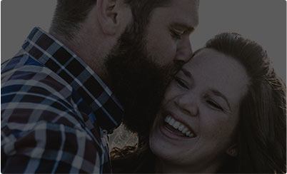 Man kissing laughing woman on cheek