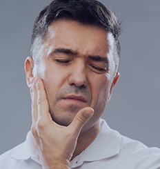 Man in pain holding jaw